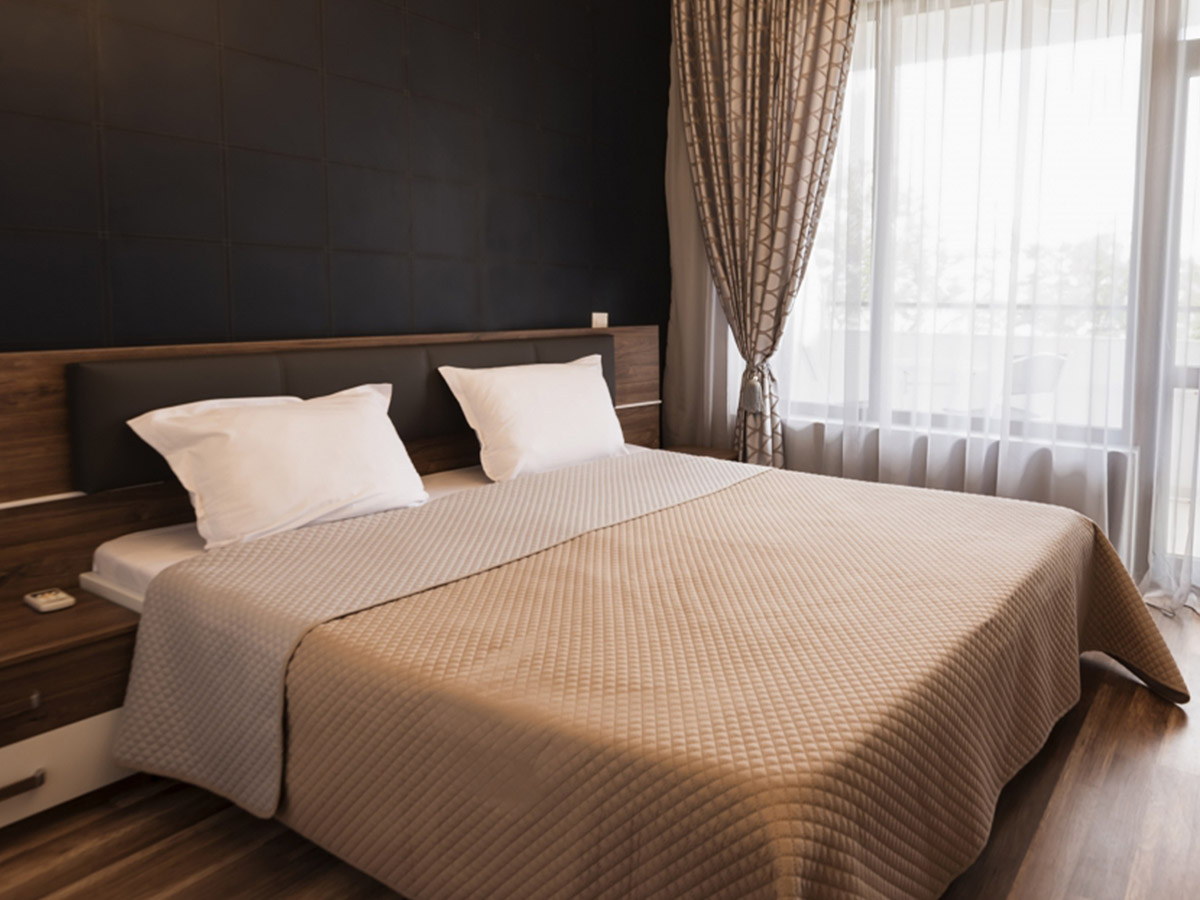 Modern bedroom with window-length drapes. 